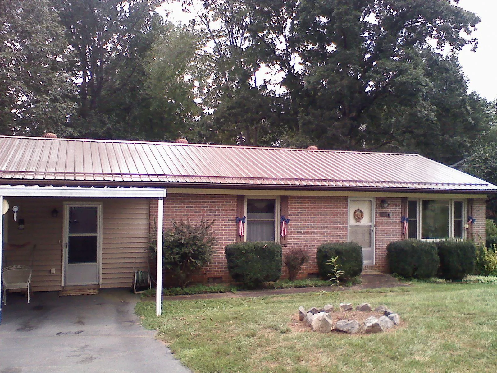 Bronze metal roof and carport on a brick ranch home — Roof Repair work by our crew in Westwego